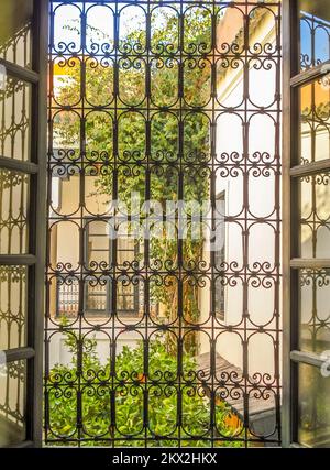 Innenhof in Marrakesch Marokko mit Orangenbäumen hinter dem Grill Stockfoto