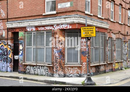 Hol dir jetzt Wohnungen mit Sicherheitsgitter an den Fenstern und Graffiti Shoreditch London Stockfoto