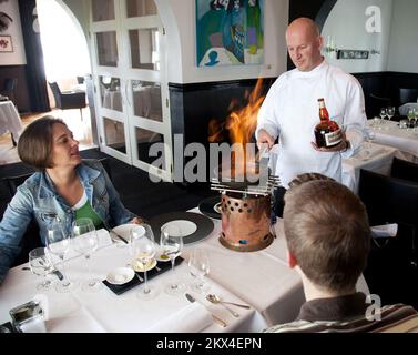 Niederlande, Tolkamer. Koch Toine Smulders vom Restaurant Villa Copera flambés am Tisch. Stockfoto