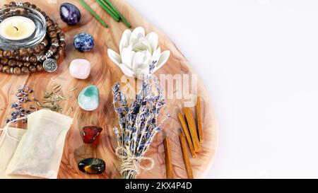 Selbsthilfe, energiesparende Zusammensetzung mit Rosenkranzperlen, Aromastiften, Chakrasteinen, Sandelholzstangen und Kerzen auf pinkfarbenem Marmorpodium mit kopiertem Spa Stockfoto