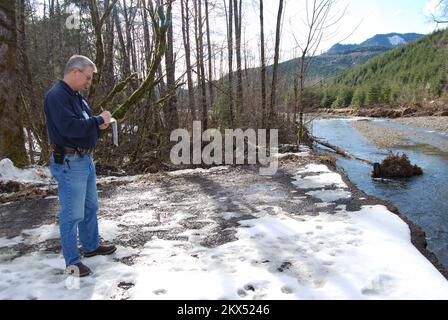 Überschwemmung Schlammlawine/Erdrutsche Schwerer Sturm Wintersturm - Morton, Wash. , 18. Februar 2009 Public Information Officer Cleo Howell notiert den Schaden an Justin Lane. Die Brücke über den Tilton River wurde am 7. Januar durch Schneefall, gefolgt von starkem Regen, ausgespült. Die Einwohner haben nun nur noch eingeschränkten Zugang zu den Häusern über eine private Holzstraße. Savannah Brehmer/FEMA. Morton, WA, 23. Februar 2009 -- Public Information Officer Cleo Howell notiert den Schaden an Justin Lane. Die Brücke über den Tilton River wurde am 7. Januar durch Schneefall ausgespült, gefolgt von schwerem rai Stockfoto