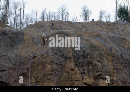 Schlammlawine/Erdrutsch Schwerer Sturm – Morton, Wasch. , 17. Februar 2009 Washington State DOT Crews kleiden diese Klippenseite entlang der SR 12 mit Kettengitter, um herabfallende Steine abzuwehren. Der „Wrap“-Prozess wird nach Erdrutschen durchgeführt, um herabfallende Steine am Hang in Vorbereitung auf die Frühjahrsregen zu mildern. Adam DuBrowa/FEMA. Washington schwerer Wintersturm, Erdrutsche, Erdrutsche und Überschwemmungen. Fotos zu Katastrophen- und Notfallmanagementprogrammen, Aktivitäten und Beamten Stockfoto