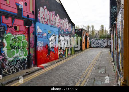 Graffiti-bedeckte Wände in Grimsby Street, Shoreditch, London, einschließlich „Screamers“ von Straßenkünstler Stik Stockfoto