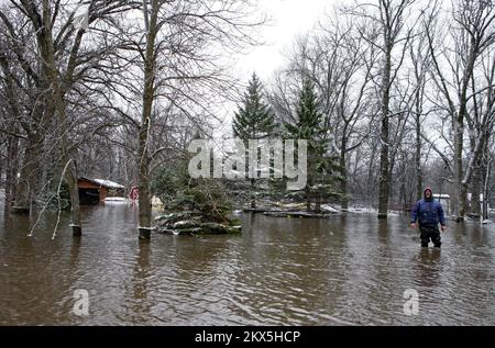 Damm/Levee Break Überschwemmung Wintersturm - Moorhead, Minnesota , 30. März 2009 Bewohner waten durch Wasser, um nach seinem überfluteten Haus am Red River in Moorhead zu sehen. Andrea Booher/FEMA. Schwere Stürme und Überschwemmungen in Minnesota. Fotos zu Katastrophen- und Notfallmanagementprogrammen, Aktivitäten und Beamten Stockfoto