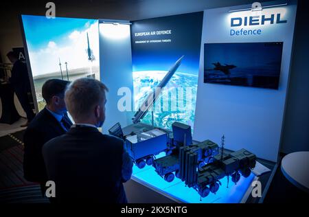 Berlin, Deutschland. 30.. November 2022. Besucher der Berliner Sicherheitskonferenz (BSC) stehen im Ausstellungsraum am Stand des deutschen Rüstungsunternehmens Diehl Defence mit einem Modell des Iris-T SLM-Luftabwehrsystems. Kredit: Michael Kappeler/dpa/Alamy Live News Stockfoto