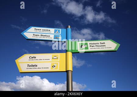 Ein moderner, vom South Ayrshire Council errichteter Fingerpost, der Touristeninformationen über die Prestwick Promenade liefert. Gelbe, blaue, grüne Zeichen, vor einem blauen Himmel Stockfoto