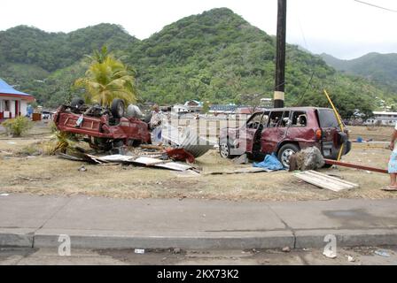 Earthquake Tsunami - Pago Pago, Amerikanisch-Samoa, 1. Oktober 2009 Pago Pago, 1. Oktober, 2009 - Ein Bewohner von American Samopa, zwei Autos, die von dem Tsumani beschädigt wurden, der Amerikanisch-Samoa traf. Erdbeben, Tsunami und Überschwemmungen in Amerikanisch-Samoa. Fotos zu Katastrophen- und Notfallmanagementprogrammen, Aktivitäten und Beamten Stockfoto