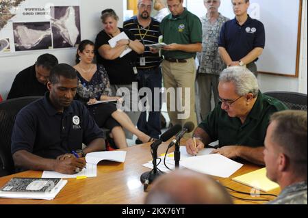Erdbeben-Tsunami - Pago Pago, Amerikanisch-Samoa, 6. Oktober 2009 Federal Coordinating Officer Kenneth Tingman und der Gouverneur von Amerikanisch-Samoa, Togiola Tulafono, unterzeichnen eine Vereinbarung. In dem Memorandum werden die Rollen und Verantwortlichkeiten zwischen dem Territorium und der Bundesbehörde für Notfallmanagement bei der Notfallwiederherstellung dargelegt. Erdbeben, Tsunami und Überschwemmungen in Amerikanisch-Samoa. Fotos zu Katastrophen- und Notfallmanagementprogrammen, Aktivitäten und Beamten Stockfoto