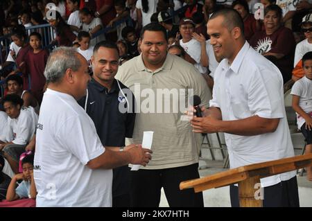 Erdbeben Überschwemmung Tsunami - Tafuna, Amerikanisch-Samoa, 28. November 2009 zur Halbzeit bei einer Highschool-Fußballmeisterschaft überreichten drei amerikanisch-samoanische NFL-Fußballspieler dem amerikanisch-samoanischen Roten Kreuz aufgrund des jüngsten Erdbebens und der Tsunami-Katastrophe $50.000 Dollar. Vaitoa Hans A. Langkilde, Vorstandsmitglied des örtlichen Roten Kreuzes, links, erhielt den Umschlag von Gabe Reid, ein ehemaliges enges Ende für die Chicago Bears, richtig. Reno Mahe, ehemaliger Philadelphia Eagles Running Back, neben Langkilde, und Fa'a Ifo Pili, ehemaliger Philadelphia Eagles Lineman. Richard O'Reilly/FEMA. Stockfoto