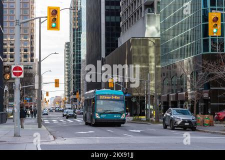 Ottawa, Kanada - 10. November 2022: Öffentlicher Bus auf der Straße in der Innenstadt. Stadtbild mit viel Verkehr und öffentlichen Verkehrsmitteln. Straße mit Kreuzung und Stockfoto