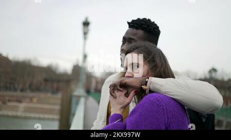 Gemischtrassiges Paar zusammen, Freund umarmt Freundin, offene Liebe und Zuneigung, küsst Hand Stockfoto