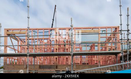 Wohnhäuser im Bau mit Metallgerüsten um sie herum. Auckland. Stockfoto