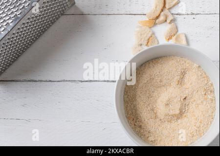 Frisch geriebener Brotkrümel in einer Schüssel auf hellem Hintergrund mit Kopierbereich. Flach verlegt Stockfoto