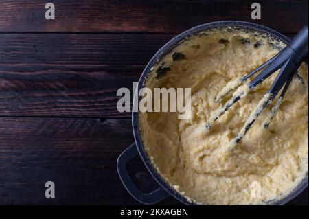 Traditionelle Polenta, frisch und hausgemacht mit Brühe, Milch, Butter und Parmesankäse Stockfoto