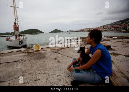 Hochwasser Hurrikan/Tropical Storm - St. Thomas, amerikanische Jungferninseln, 31. August, 2010 St. Thomas Anwohner Andy Evans (R) spricht mit ihrem Vater Gary Evans (L) am Ufer von Charlotte Amalie, umgeben von Trümmern, die von den Winden des Hurricane Earl an Land geworfen werden; ein Fischerboot, das noch immer an seiner Anlegestelle befestigt ist, wird als gekentert (Mitte) gesehen, während ein anderer Mariner die Schäden eines schmuddeligen (L) entdeckt. Andrea Booher/FEMA... Fotos zu Katastrophen- und Notfallmanagementprogrammen, Aktivitäten und Beamten Stockfoto