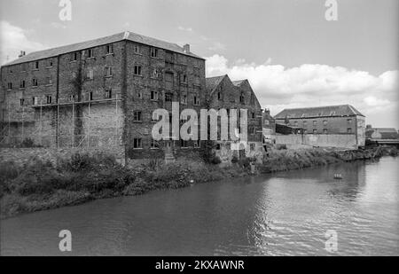 Anfang 1980er Schwarzweiß-Archivfoto alter Lagerhäuser am NW-Ufer des Flusses Nene in Wisbech, Cambridgeshire. Stockfoto