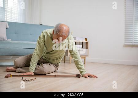 Kopfschmerz älterer Senioren auf dem Boden nach dem Sturz Stockfoto