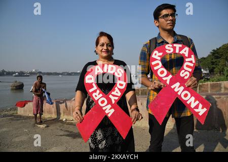 30. November 2022, Kalkutta, Indien: Eine freiwillige Gruppe organisiert eine Kampagne zur Prävention gegen AIDS, wobei sie die rote Band am Ufer des Ganges vor dem Welt-Aids-Tag am 30. November 2022 in Kalkutta, Indien, hält. (Foto: Biswarup Ganguly/Eyepix Group) Stockfoto