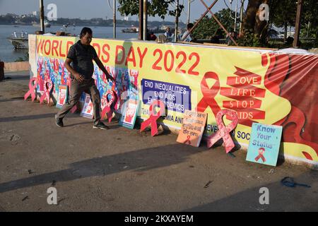 30. November 2022, Kalkutta, Indien: Eine freiwillige Gruppe organisiert eine Kampagne zur Prävention gegen AIDS, wobei sie die rote Band am Ufer des Ganges vor dem Welt-Aids-Tag am 30. November 2022 in Kalkutta, Indien, hält. (Foto: Biswarup Ganguly/Eyepix Group) Stockfoto