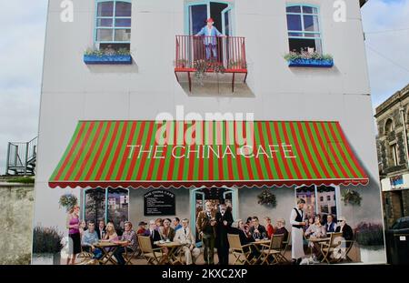 Suzan Vagoose - The China Cafe, St Austell, Cornwall - Daphne du Maurier blickt vom Balkon, während andere Berühmtheiten sich unten treffen. Stockfoto