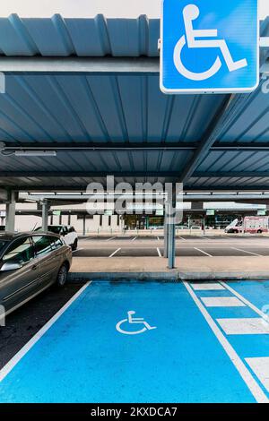 Kostenloser Behindertenparkplatz auf blauem Asphalt mit dem internationalen Behindertensymbol in Weiß und dem hellblauen des Stockfoto