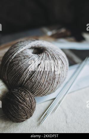Bälle aus Wollgarn und Stricknadeln zum Handstricken. Konzept für Handarbeit. Stockfoto