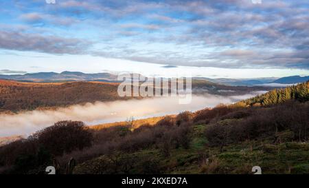 Blick von Gummers wie auf der Fell Foot Brow Road mit Blick auf die Südspitze von Windermere mit wunderschönem Nebel, der das Sonnenlicht einfängt, Lake District National Stockfoto