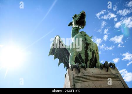 Die Drachenstatue steht an einem schönen und sonnigen Tag auf der Drachenbrücke in Ljubljana in Slowenien. Stockfoto