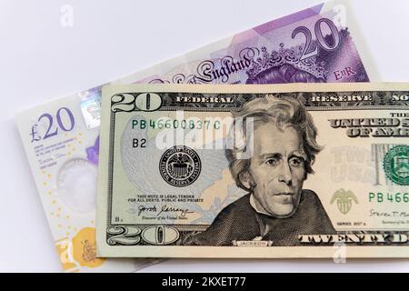 Ein 20-Dollar-Schein und ein 20-Pfund-Sterling-Schein, isoliert auf weißem Hintergrund. Stockfoto