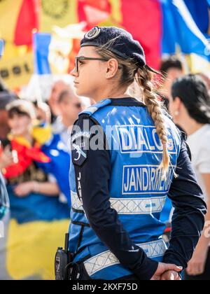Bukarest, Rumänien - Oktober 2022: Weibliche Polizeibeamte und Gendarmerie oder Militärpolizei, die die Demonstranten bei einem Protest in B streng überwachen Stockfoto