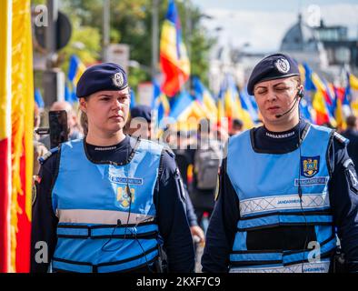 Bukarest, Rumänien - Oktober 2022: Weibliche Polizeibeamte und Gendarmerie oder Militärpolizei, die die Demonstranten bei einem Protest in B streng überwachen Stockfoto