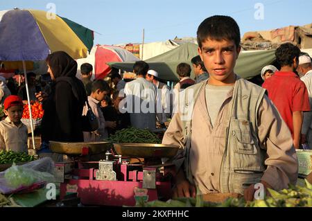 Kabul/Afghanistan: Ein junger afghanischer Mann, der Gemüse an einem Marktstand in Kabul verkauft. Stockfoto