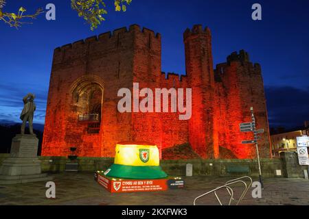 Caernarfon Castle, rot beleuchtet zum Gedenken an die Fußballmannschaft von Wales, Weltmeisterschaft 2022, Gwynedd, North Wales, Vereinigtes Königreich, Stockfoto