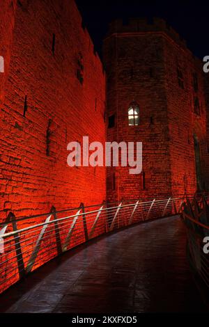 Caernarfon Castle, rot beleuchtet zum Gedenken an die Fußballmannschaft von Wales, Weltmeisterschaft 2022, Gwynedd, North Wales, Vereinigtes Königreich, Stockfoto