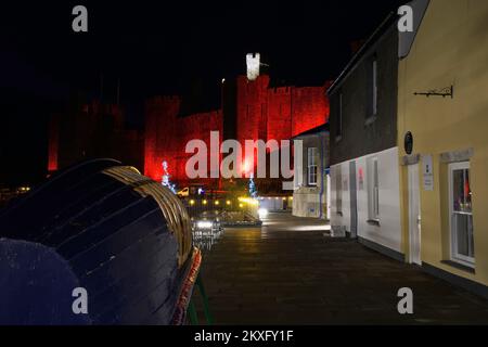 Cwrt Celf mit Caernarfon Castle, rot beleuchtet zum Gedenken an die Fußballmannschaft von Wales, Weltmeisterschaft 2022, Gwynedd, Nordwales, Vereinigtes Königreich, Stockfoto