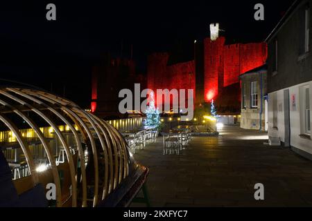 Cwrt Celf mit Caernarfon Castle, rot beleuchtet zum Gedenken an die Fußballmannschaft von Wales, Weltmeisterschaft 2022, Gwynedd, Nordwales, Vereinigtes Königreich, Stockfoto