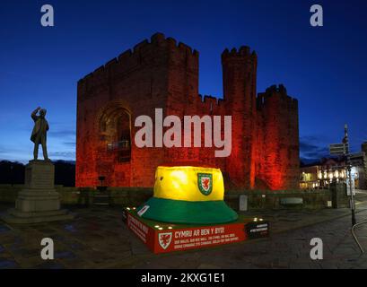 Caernarfon Castle, rot beleuchtet zum Gedenken an die Fußballmannschaft von Wales, Weltmeisterschaft 2022, Gwynedd, North Wales, Vereinigtes Königreich, Stockfoto