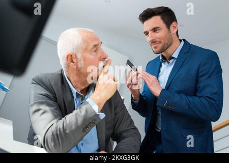Ein seriöser Geschäftsmann und ein jüngerer Stockfoto