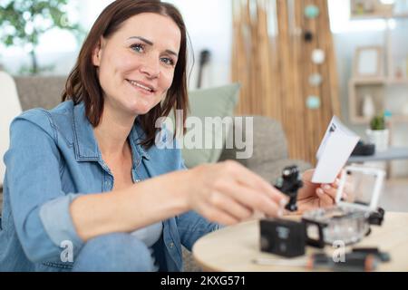 Frau, die zu Hause ein elektrisches Gerät repariert Stockfoto