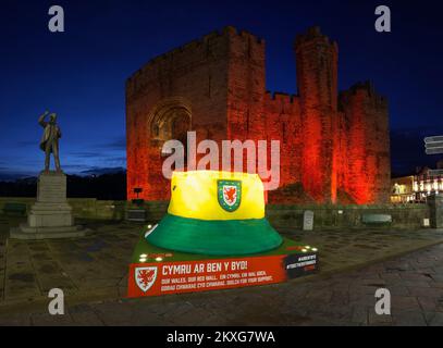 Caernarfon Castle, rot beleuchtet zum Gedenken an die Fußballmannschaft von Wales, Weltmeisterschaft 2022, Gwynedd, North Wales, Vereinigtes Königreich, Stockfoto