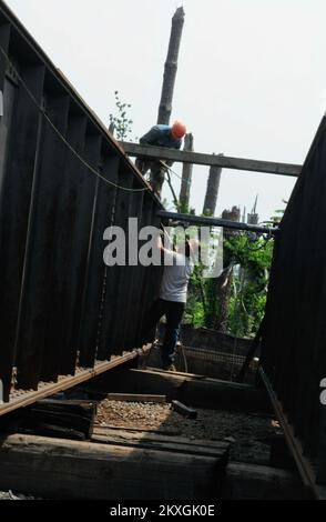 Tornado – Holt, Alabama , 19. August 2011 - Schweißer richten Stahl gerade, um einen Abschnitt der Hurricane Creek Train Bridge zu reparieren, nachdem ein Tornado vom 27.. April durch die Mitte gerissen wurde. Hurricane Creek Bridge ist die älteste und längste Eisenbahnbrücke im Südosten und wurde zwischen 1909 und 1913 erbaut. Es gehört jetzt der Alabama Southern Railroad, einer 85 km langen Strecke, die östlich von Columbus, MS, nach Birmingham, AL verläuft. Die Reparatur an der Brücke begann am 25.. Mai und wird voraussichtlich bis November andauern. Zurzeit werden Züge nach Birmingham umgeleitet. Die Gemeinschaft holt arbeitet eng mit FE zusammen Stockfoto