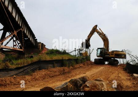 Tornado – Holt, Alabama , 19. August 2011 - Ein Bulldozer hebt Betonschaufeln an, um einen Abschnitt der Hurricane Creek Train Bridge zu reparieren, nachdem ein Tornado vom 27.. April durch die Mitte gerissen wurde. Hurricane Creek Bridge ist die älteste und längste Eisenbahnbrücke im Südosten und wurde zwischen 1909 und 1913 erbaut. Es gehört jetzt der Alabama Southern Railroad, einer 85 km langen Strecke, die östlich von Columbus, MS, nach Birmingham, AL verläuft. Die Reparatur an der Brücke begann am 25.. Mai und wird voraussichtlich bis November andauern. Zurzeit werden Züge über Birmingham umgeleitet. Die Gemeinde holt arbeitet an clos Stockfoto
