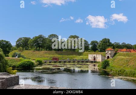 Kopenhagen, Dänemark - 24. Juli 2022: Landschaft, grüne Dreckmauern und Graben östlich des Südeingangs mit Brücke in den historischen Militärstützpunkt Kastellet Stockfoto