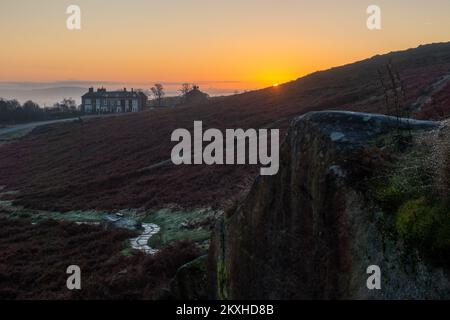 Sonnenaufgang im Cow and Calf Inn am Ilkley Moor im Herbst mit Nebel im Tal. UK Stockfoto