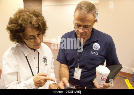 Überschwemmung Hurrikan/Tropischer Sturm - Neptune, N. J. , 6. September 2011 die FEMA-Führung bereitet sich auf eine Pressekonferenz vor, die von New Jersey Governor Christopher James 'Chris' Christie in einem FEMA Joint Field Office (JFO) in Neptune ausgerichtet wird. William „Bill“ Vogel, Federal Coordinating Officer (FCO) der FEMA, berät sich mit Phyllis Deroian, Außenminister, Bevor Herr Vogel an der Pressekonferenz teilnimmt, um die Medien und die Öffentlichkeit über die laufenden Bemühungen der FEMA auf dem Laufenden zu halten, die staatlichen und lokalen Regierungen bei ihrer Reaktion auf die durch den Hurrikan Irene am 28. August verursachten Überschwemmungen und Windschäden zu unterstützen. Neu Stockfoto
