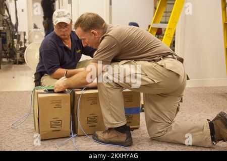 Flooding Hurricane/Tropical Storm - Neptune, N. J. , 6. September 2011 Tom Bowman (blaues Hemd), ein MERS Radio Frequency Technician, Und Tom Spain, ein MERS Safety Disaster Preparedness Officer (DPO), verlegt Kabel dafür, während das FEMA Logistics Team ein JFO in Neptune für FEMA-Spezialisten vorbereitet, die an DR-4021-NJ arbeiten Mitglieder des Mobile Emergency Response Support (MERS) unterstützen die Mission der FEMA, indem sie FEMA-Spezialisten Hochgeschwindigkeits-Konnektivität und eine sichere Einrichtung zur Verfügung stellen, in der sie arbeiten, kommunizieren und Überlebenden von Katastrophen sowie den staatlichen und lokalen Regierungen bei ihrer Reaktion auf Überschwemmungen helfen können Stockfoto