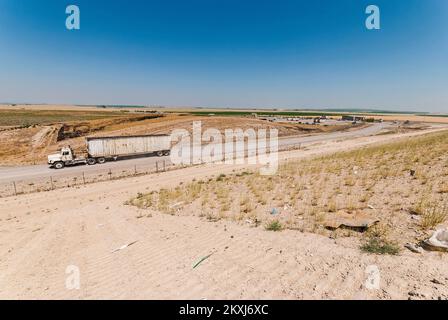 Ein Sattelschlepper fährt auf einer aktiven Deponie außerhalb eines Depots. Stockfoto