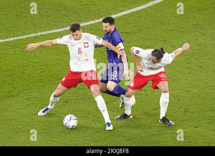 Argentiniens Lionel Messi (Zentrum) kämpfte um den Ball mit dem polnischen Krystian Bielik (links) und Grzegorz Krychowiak während des Gruppenspiels der FIFA-Weltmeisterschaft Gruppe C im Stadium 974 in Doha, Katar. Bilddatum: Mittwoch, 30. November 2022. Stockfoto