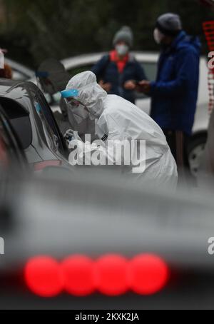 Medizinisches Personal in Schutzstationen wird beobachtet, wie Menschen auf das Coronavirus getestet werden. Die Bürger werden in einer Autoklinik in Siget auf Coronavirus getestet. In den letzten 24 Stunden wurden 4.135 neue Fälle registriert, so dass die Zahl der aktiven Fälle in Kroatien heute 25.270 beträgt. Von ihnen befinden sich 2.792 Patienten im Krankenhaus, von denen 295 Atemschutzmasken tragen. In den letzten 24 Stunden erholten sich 3.793 Personen und 11.114 wurden getestet. Kroatien hat die höchste Zahl von Fällen pro 100.000 Einwohner unter den europäischen Ländern, in Zagreb, Kroatien, am 12. Dezember 2020. Foto: Zeljko Lukunic/PIXSELL Stockfoto