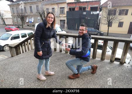 Dekan Jadanic machte seiner Freundin Ana Krznarevic am 9. Januar 2021 in den Ruinen einen Heiratsantrag vor dem Gesundheitszentrum in Petrinja, Kroatien. Sie trafen sich vor vier Jahren im Laden, wo sie arbeitete, an ihrem Geburtstag. Sie haben ein paar Monate später eine Beziehung begonnen und sind seitdem unzertrennlich. Dean arbeitet seit dreizehn Jahren als Medizintechniker am Petrinja Health Center, und nach dem letzten Erdbeben am 29. Dezember zog er sich kaum den Kopf raus. Jetzt helfen beide freiwillig den Opfern des Erdbebens, so dass sie selten einen sehen Stockfoto